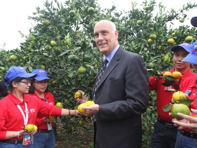 沃爾瑪中國(guó)公司事務(wù)高級(jí)副總裁博睿（中）考察大理項(xiàng)目基地，并同沃爾瑪員工志愿者一起幫助受助農(nóng)戶收獲成熟的柑橘。